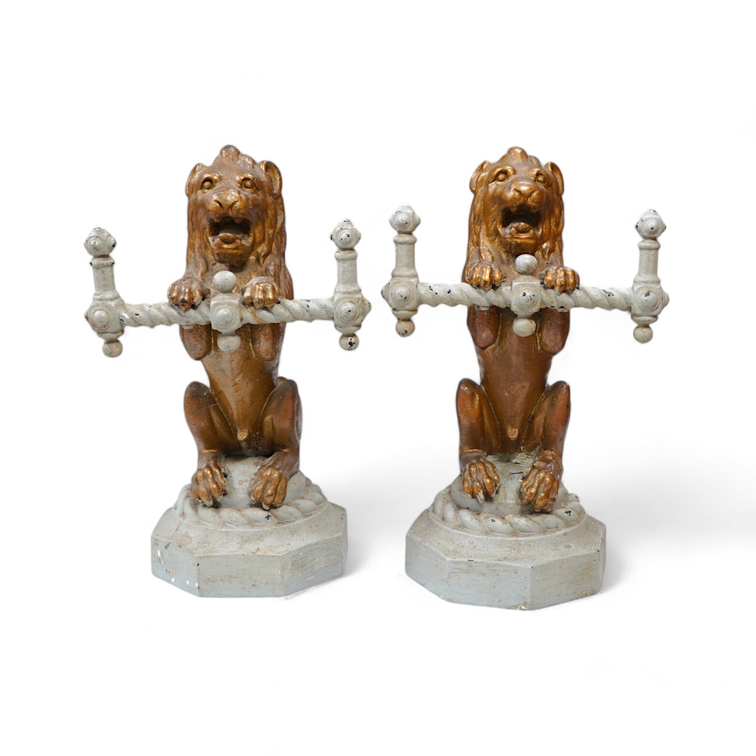 A pair of cast iron fire dogs in the form of triumphant lions, painted, 38cm high, 23cm wide. Condition - fair